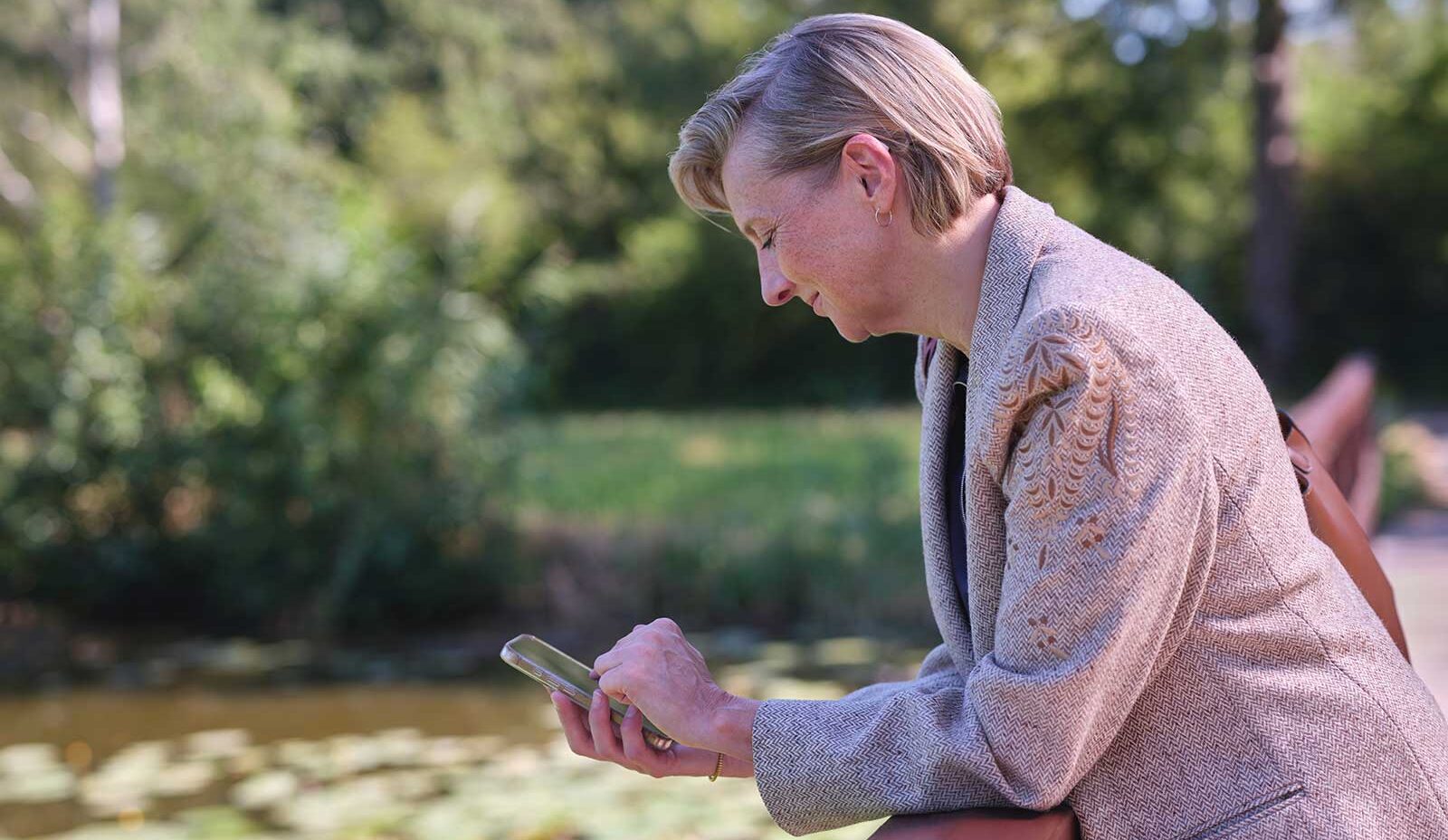 woman-standing-by-lake-phone-eon